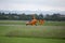 Small and Light Orange Helicopter Taking off from the Runway