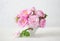 Small light pink bouquet of Roses in porcelain vase against of pale grey background.  Shallow depth of field. Selective focus