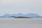 Small lighthouse on an islet of Vega archipelago in Norwegian sea against the background of GullsvÃ¥gfjellet Mountain