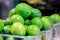 Small lime lemons in plastic bowls put up for sale at the Boqueria market.