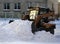 Small loader rakes fallen snow