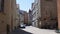 A small lonely street in the historic center of Regensburg Germany in the summer. A man and a woman are walking along