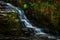 Small Long Exposured Creek With Waterfall In Mystic Forest Near Ullapool In Scotland