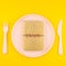 Small love golden diary love symbol plate serving plastic tableware copy space on bold yellow background in creative minimal style