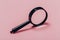 Small magnifying glass on pink background