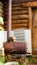 A small metal stove stands above the bricks in the grass in the Yakut Northern greenhouse.