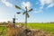 Small metal windmill and a large wooden hollow post mill in a Du