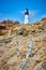 Small mineral quartz vein in rocks leading to white lighthouse