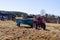 Small mini red tractor stands on a farm yard. Springtime and harvest concept.