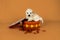 Small miniature toy poodle with white curly fur in a cookiejar against orange background