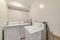 Small and minimalist laundry room of house with washing machine and dryer