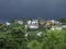 A small modern mountain village surrounded by a dense mixed forest in the background of clouds before the rain. Family and