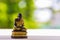 A small monk statue on white wooden table with nature background