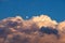 Small moon above large, storm cloud, during the day