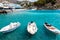 Small moored fishing boats in blue lagoon of Crete island.