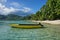 Small motor boat moored on sandy shore Huahine