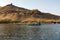 Small motor boat for tourists on the Nile River in Cairo Egypt, in the background ruins of an ancient Arab town in the desert. T