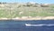 Small motor fishing boat driving along the coast of Malta