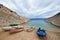 Small motor rental boats on cozy harbor coast among high rocky shores tied to pier with ropes