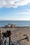 Small motor winch and anchors and small wooden fishing rowboats on a sandy beach