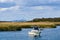 A small motorboat is moored in Broad Channel Queens, with the view of Lower Manhattan in the distance