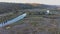 Small motorboat sails on long curvy river running on meadows