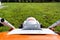 A small motorized electric mower standing on the lawn, it is orange in color.