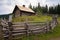 a small mountain lodge with a fence made of logs and twigs