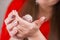 A small mouse sits on female hands with a beautiful manicure