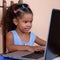 Small multiracial girl working on a laptop computer