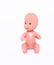 A small naked doll sits on an isolated white background. Close-up