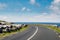 Small narrow asphalt road by Atlantic ocean, Black Head Lighthouse area, Burren, Ireland. warm sunny day. Blue cloudy sky. Nobody