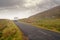 Small narrow asphalt road in Connemara in the mountains area White motor home going up the hill. County Galway, Ireland, Low