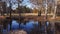 Small narrow lake in autumn park at sunny windy day