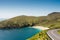 Small narrow road to Keem beach, Achill island in county Mayo, Ireland, warm sunny day. Clear blue sky and water of the Atlantic