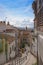 A small narrow street with white houses and abundant greenery in the old European city