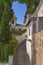 A small narrow street with white houses and abundant greenery in the old European city