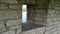 Small narrow window in the old ancient stone wall of Kremlin Pskov, Russia. View of the river through the gap. Concept of chance o