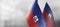 Small national flags of the Haiti on a light blurry background