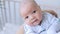 a small newborn baby boy in his mother's arms in the nursery with his eyes open, close-up