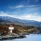 Small Norwegian lighthouse under blue sky