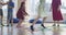 Small nursery school children with female teacher on floor indoors in classroom, doing exercise. Jumping over hula hoop