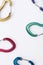 Small objects. Many of the multi colored carabiners on lying on the white table