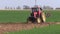 Small old agriculture tractor cultivated field in spring