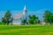 A small old fashioned white chapel sits in a peaceful green meadow in Texas