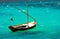 small and old fishing wooden boat with nobody on board sailing in the green Aegean sea. The wooden boa is waiting at harbor