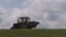 Small old tractor fertilize farm crop field in spring