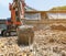 Small orange excavator or macro truck digging soil for build foundation pile in construction site