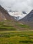 Small orange tent under the glacier. Extreme overnight stay in the mountains. Peace and relaxation in nature