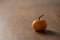 Small organic tangerine with stem on wood table